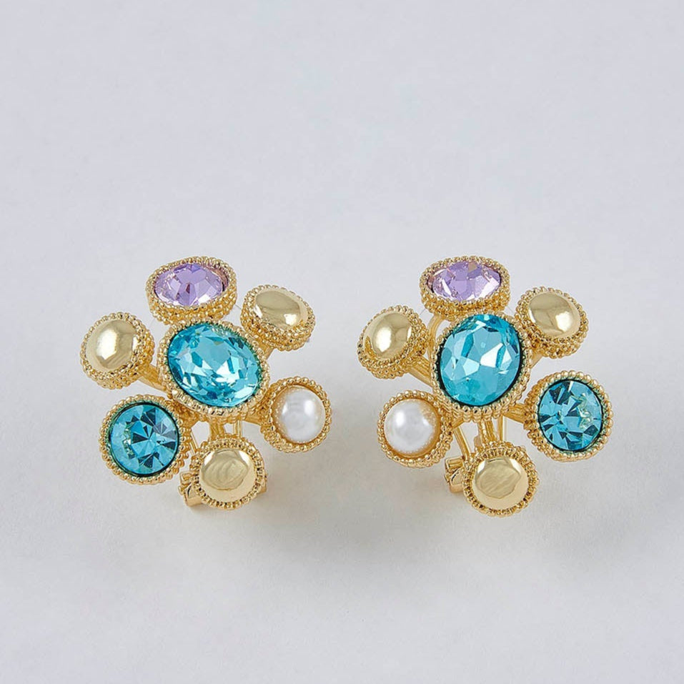 Pair of earrings with colorful gemstones on a light gray background