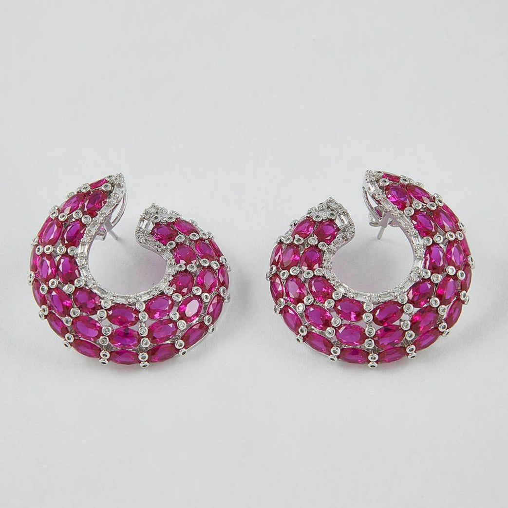 Pair of pink hoop earrings on a light gray background