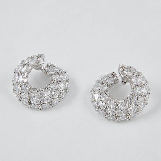 Pair of silver hoop earrings with clear stones on a light gray background