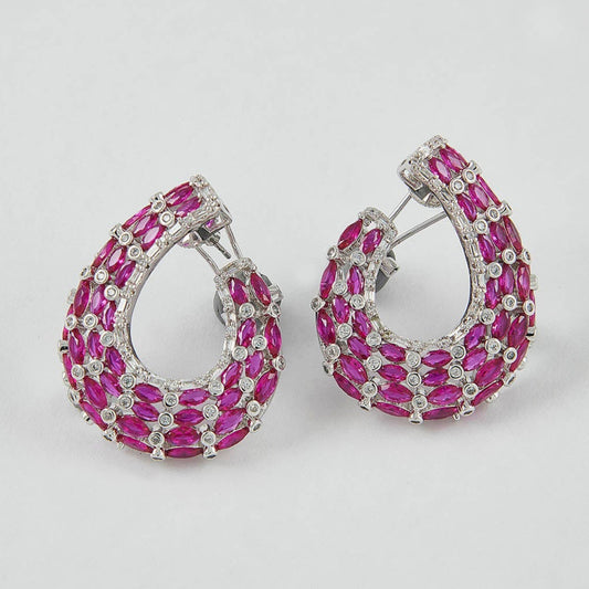 Pair of hoop earrings with pink gemstones on a light gray background