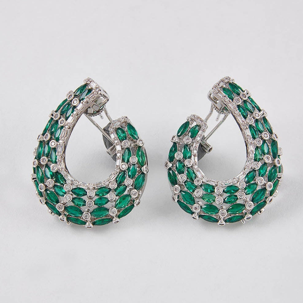 Pair of hoop earrings with green gemstones on a light gray background