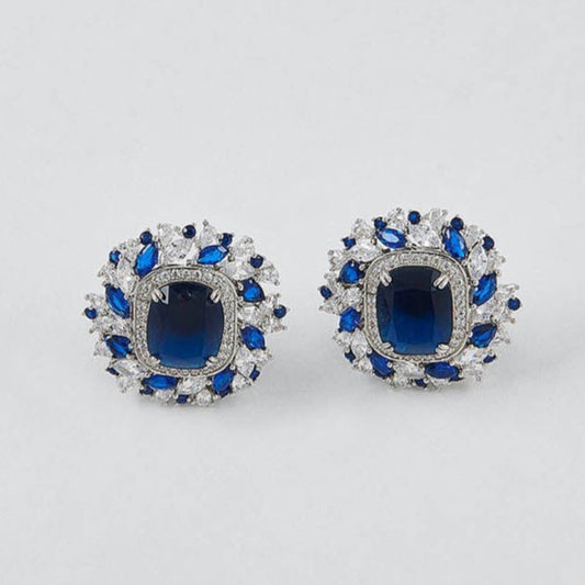 Pair of earrings with blue gemstones on a light gray background