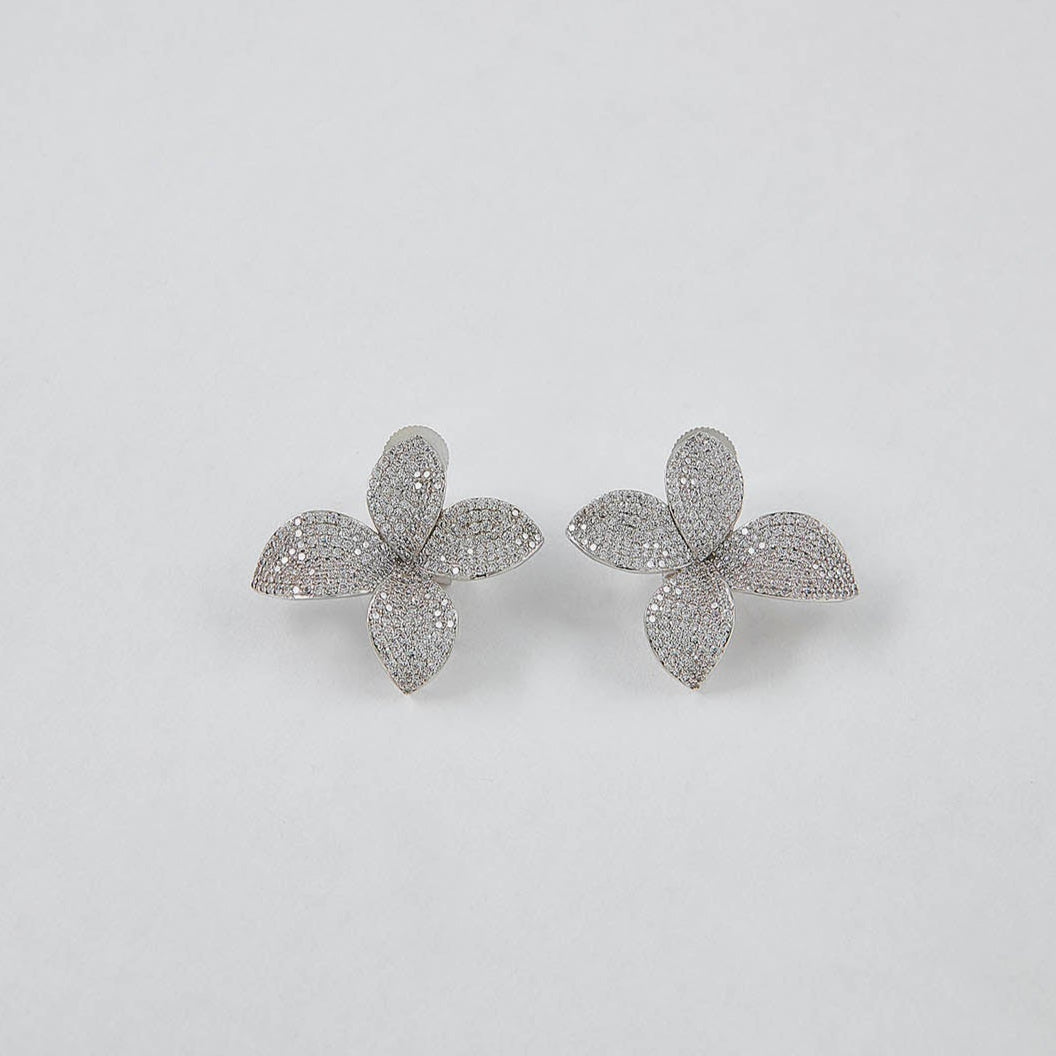 Flower-shaped earrings on a light gray background