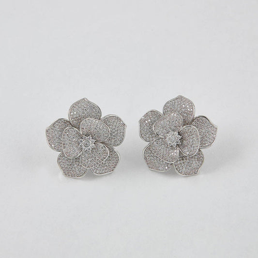 Pair of silver flower-shaped earrings on a white background