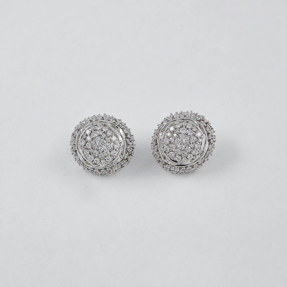 Pair of silver earrings with gemstones on a light gray background
