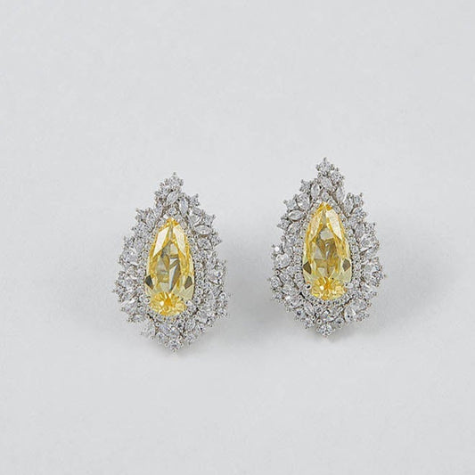 Pair of earrings with yellow gemstones on a light gray background