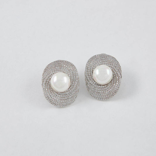 Pair of silver earrings with pearl centers on a light gray background
