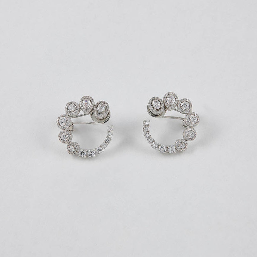 Pair of silver hoop earrings with small diamonds on a light gray background
