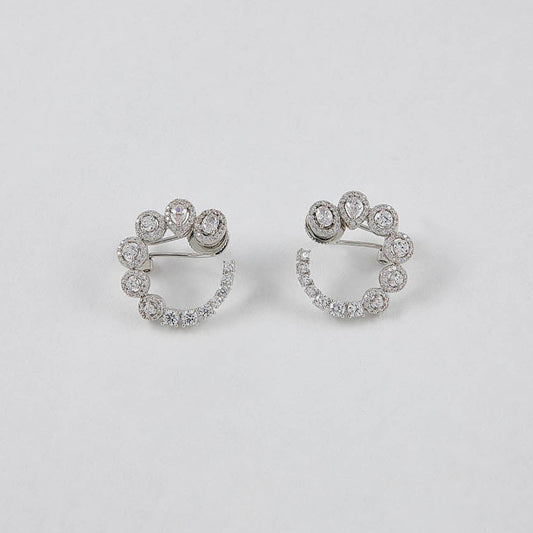 Pair of silver hoop earrings with small diamonds on a light gray background