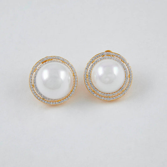 Pair of pearl earrings with gold accents on a light gray background
