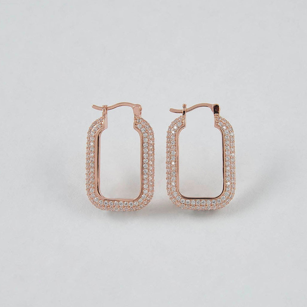 Rose gold hoop earrings on a light gray background